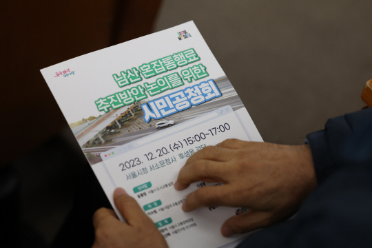 남산 혼잡통행료 추진 방안은?      (서울=연합뉴스) 임화영 기자 = 20일 서울시청 서소문청사 후생동 강당에서 열린 남산 혼잡통행료 추진방안 논의를 위한 시민공청회에 참석한 시민이 발제 자료를 살펴보고 있다. 2023.12.20      hwayoung7@yna.co.kr  (끝)